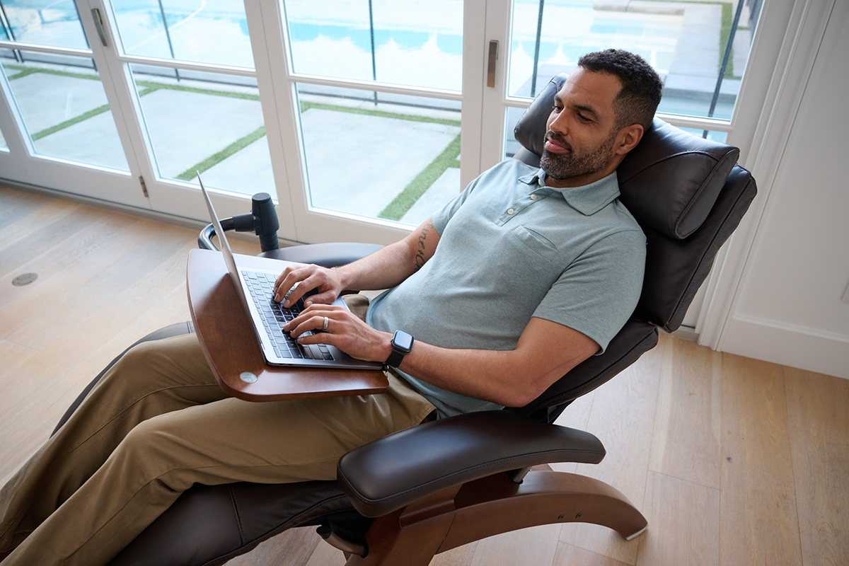 Man working on laptop in ergonomic chair